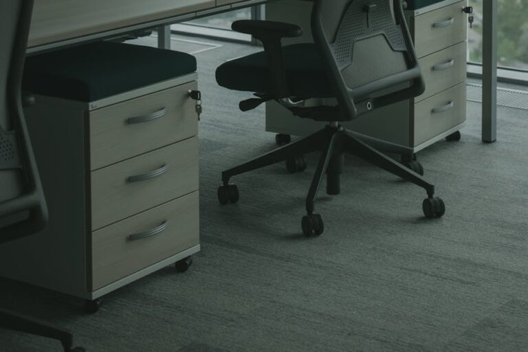 A sleek office setup featuring ergonomic chairs and drawer units in a well-lit space.