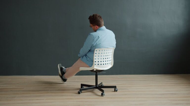 Rear view of a man spinning on a swivel chair in a minimalist interior setting.