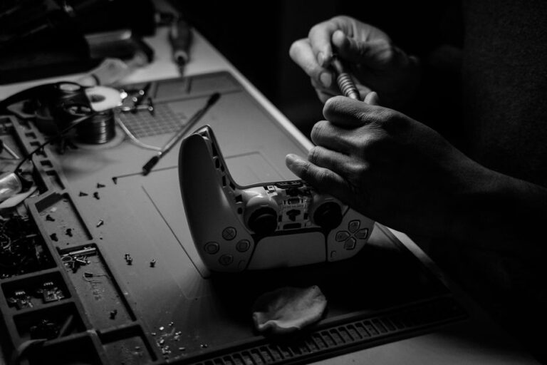 close up black and white image showing hands repairing a gam