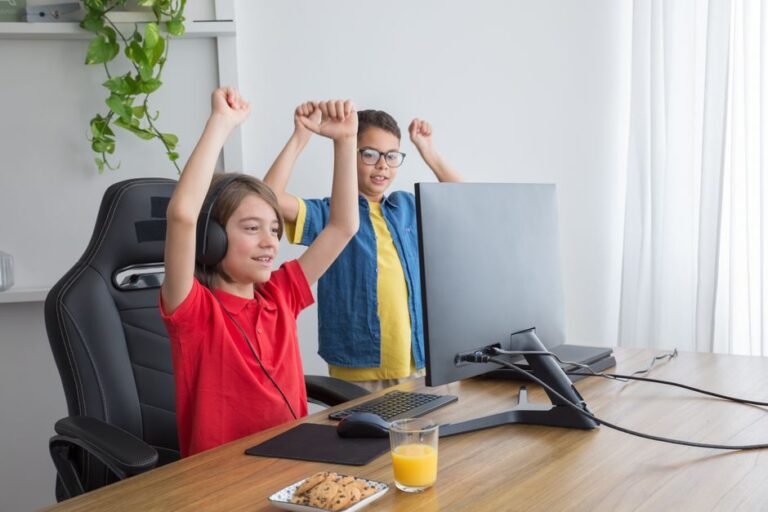 Two kids having fun playing a computer game indoors, celebrating a win.
